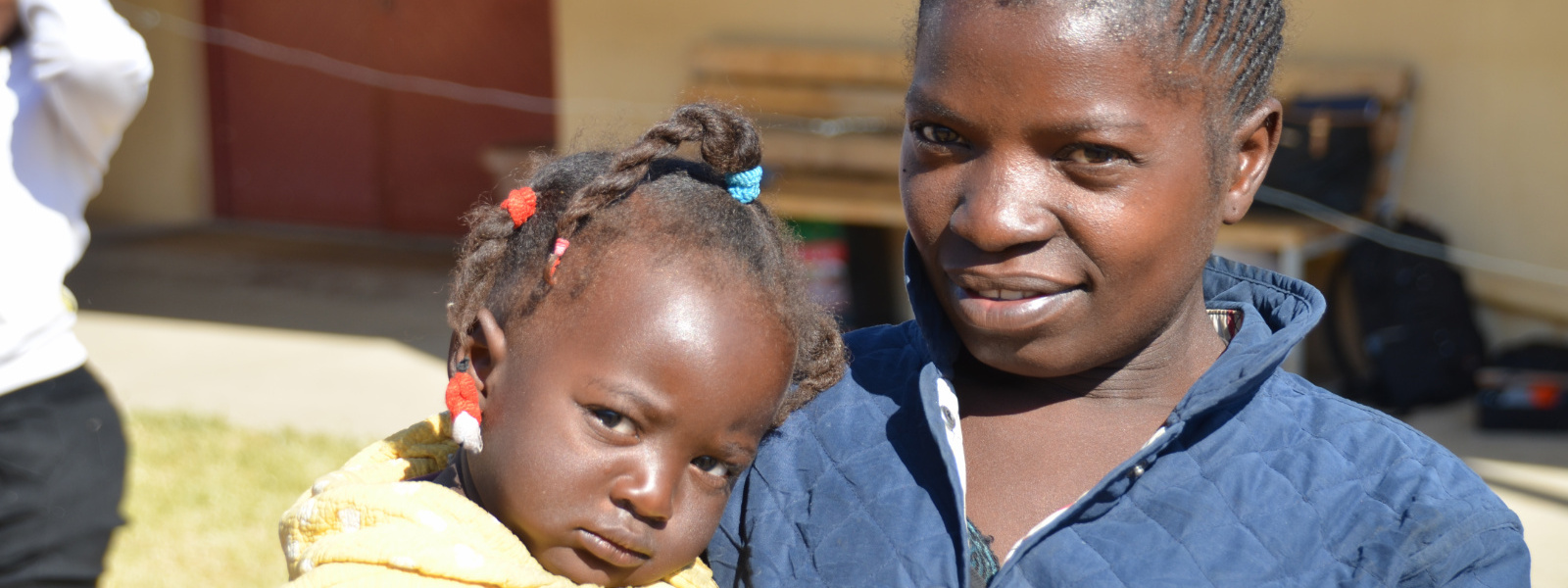 Smiling young woman with pouting child in Angola, client of Hope for Our Sisters