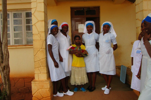 Five African nurses with very young woman and newborn child