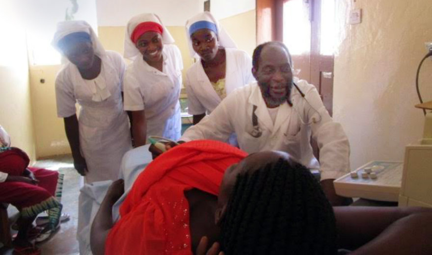 Nurses surrounding African woman in labor, helping her to give birth