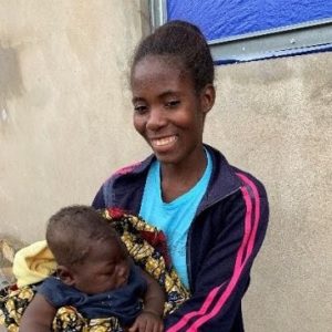Angolan woman smiling and holding her baby