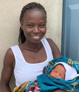 Angolan woman smiling and holding her newborn