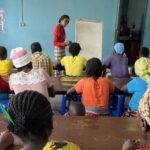 Classroom full of Angolan women learning literacy skills