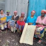 Congolese women holding hand-woven mats and baskets