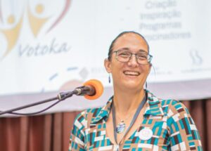 Smiling white woman at a microphone